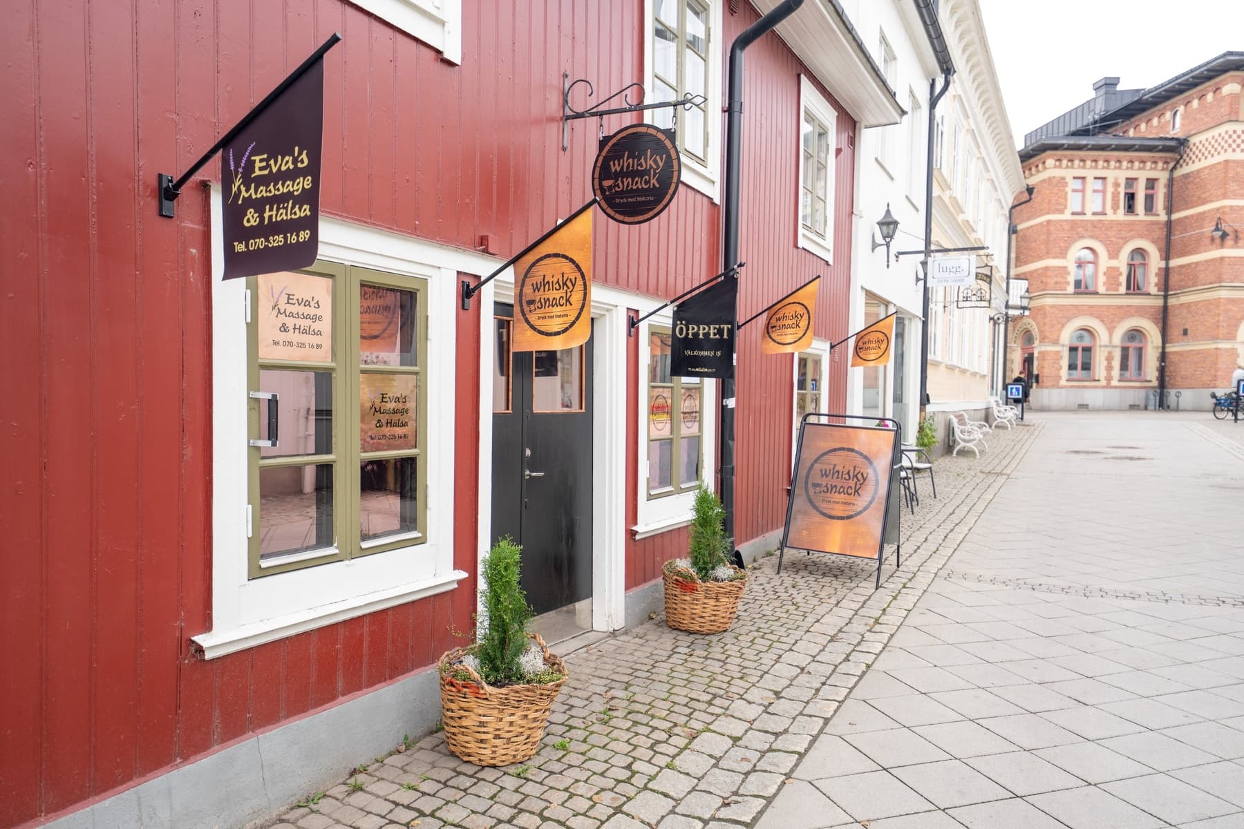 Den röda träfasaden på Sjötullsgatan 2B i Norrtälje, med skylten Eva's Massage & Hälsa vid entrén