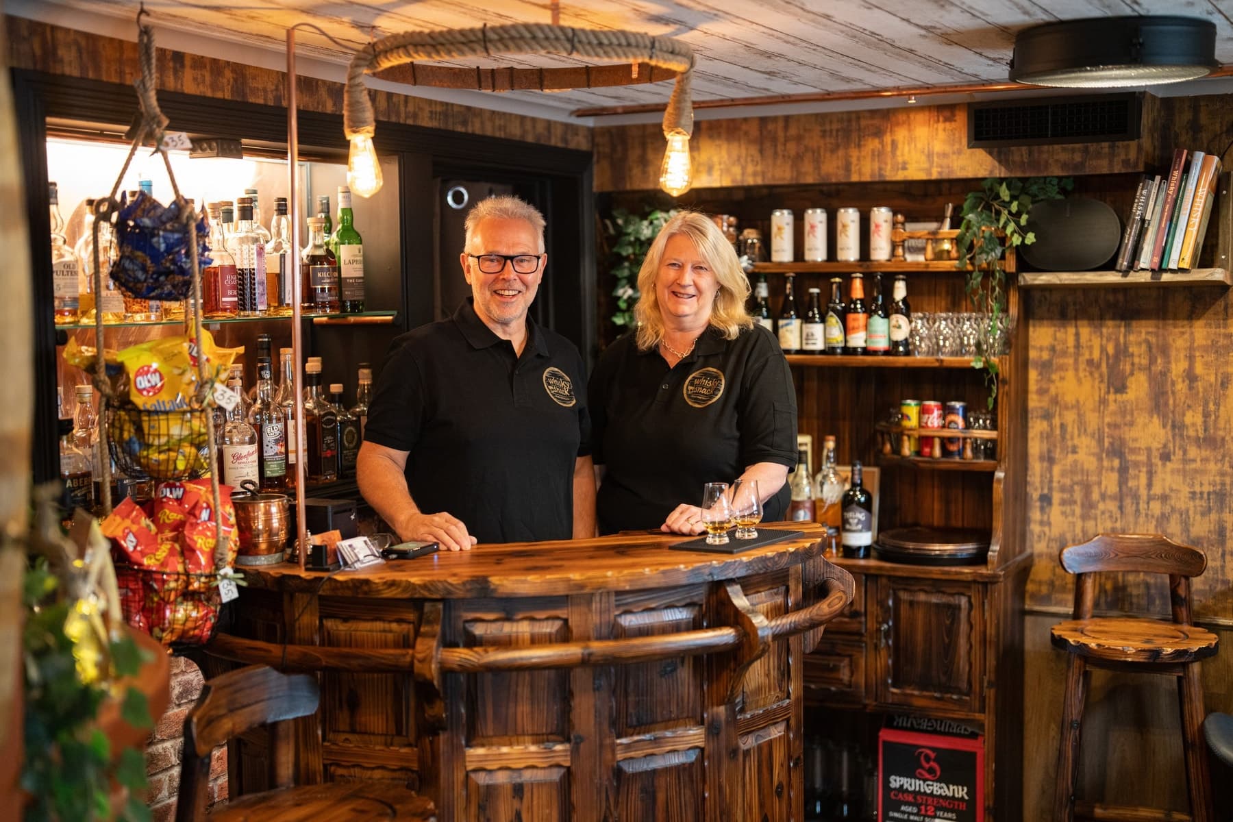 Eva och Kent bakom bardisken i whiskybaren, som delar lokal med behandlingsrummet
